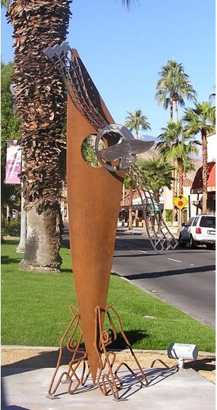 "Mojave Sails" depicts four people at the base of the sculpture, raising and supporting the sail, which has a kinetic element in the shape of a bird at the top.